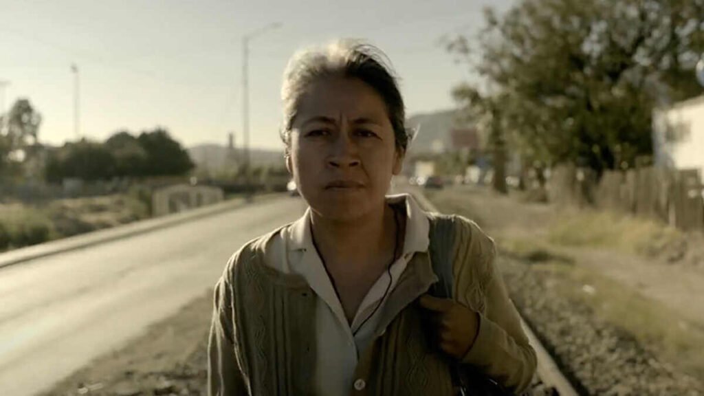 Fotografia de Mercedes Hernandez protagonizando a Magdalena, caminando sobre una carretera con un aspecto de angustia.